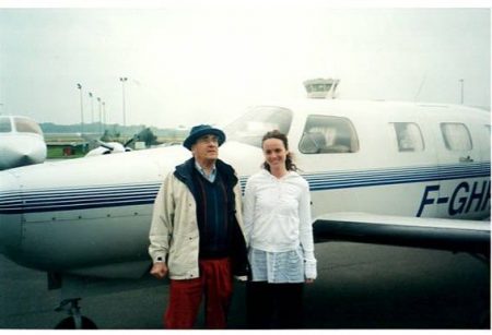 Michel Legrand & Melissa Errico standing in front of a small airplane